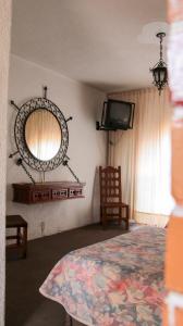 - une chambre avec un lit, un miroir et une chaise dans l'établissement Ideal Ixtapan, à Ixtapan de la Sal