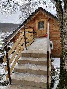 a log cabin with stairs leading to the door at Apartman Tonka in Otočac