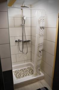 a shower in a white tiled bathroom at Apartman Tonka in Otočac