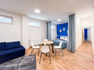 Una sala de estar con un sofá azul y una mesa y sillas. en Sauna Apartment - Brno(x) Cejl, en Brno 23 fotos más
