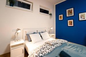ein Schlafzimmer mit einer blauen Wand und einem Bett in der Unterkunft Sauna Apartment - Brno(x) Cejl in Brünn
