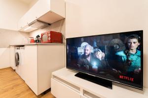 einen großen Flachbild-TV auf einer Theke in einer Küche in der Unterkunft Sauna Apartment - Brno(x) Cejl in Brünn