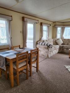 a living room with a table and chairs and a couch at Beautiful Caravan in Ingoldmells