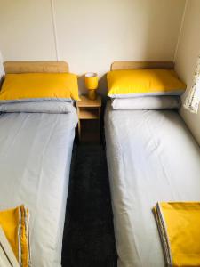 two beds sitting next to each other in a room at Cosy holiday home at Romney Sands in New Romney