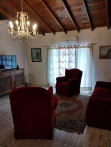 a living room with two red chairs and a chandelier at Alojamiento Entero, Aeropuerto Ezeiza in Ezeiza