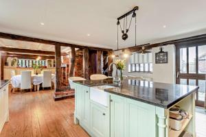 a kitchen with a counter top and a dining room at Beautiful 10 Bed Oak beamed Country House in Tibenham