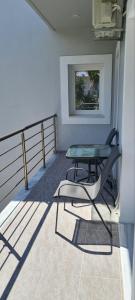 een tafel en een stoel op een balkon bij Brand new cozy apartment in Mesaíon Karlovásion