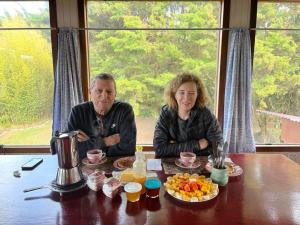 un hombre y una mujer sentados en una mesa con comida en Apartamento ArteSAna, en Monteverde