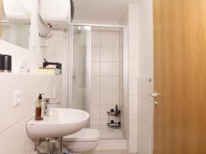 W łazience znajduje się umywalka, toaleta i prysznic. w obiekcie BohnApartments Elisa - Wohlfühlapartment mit 2 gratis Parkplätzen und 3 Schlafzimmern - WLAN - Vollausstattung w mieście Erfurt