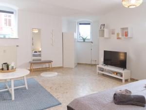 Sala de estar blanca con TV y mesa en BohnApartments Elisa - Wohlfühlapartment mit 2 gratis Parkplätzen und 3 Schlafzimmern - WLAN - Vollausstattung en Erfurt