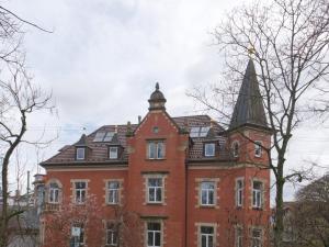 duży budynek z czerwonej cegły z wieżą w obiekcie BohnApartments Elisa - Wohlfühlapartment mit 2 gratis Parkplätzen und 3 Schlafzimmern - WLAN - Vollausstattung w mieście Erfurt