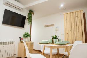 una sala da pranzo con tavolo, sedie e TV di Serranos 24 Apartamento Rector Cobos a Salamanca