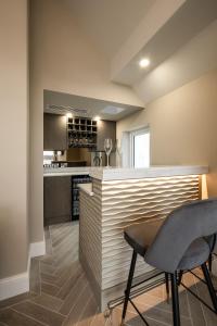 a kitchen with a bar with two chairs and a table at Atlantic View in Portstewart