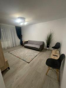 a living room with a bed and two chairs in it at Apartament la Nicole ultracentral Bld Roman bloc 39 in Roman