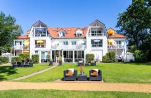 a large white building with chairs in front of it at Ferienwohnung Juliane in der Villa zum Kronprinzen direkt gegenüber der Saarow Therme in Bad Saarow