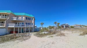 a building on the beach with palm trees and condos at Claire's Rendezvous in Tybee Island
