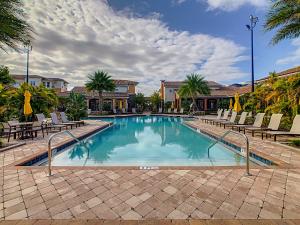 een zwembad met stoelen en een resort bij Spacious Apartment Near Disney in Kissimmee