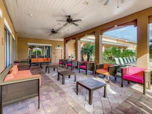 un patio con sillas coloridas, mesas y ventanas en Spacious Apartment Near Disney en Kissimmee