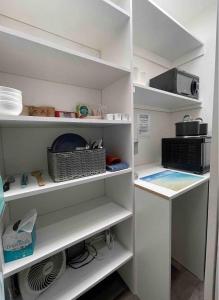 a walk in closet with white shelves at Spacious, Luxury Ocean Master Suite 2 BD With Kitchenette in San Diego