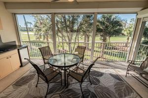 una sala da pranzo con tavolo e sedie in vetro di Flamingo Fairways II a Lely Resort