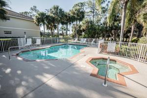 una piscina con recinzione e alberi di Flamingo Fairways II a Lely Resort