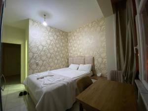 um quarto com 2 camas e uma mesa de madeira em Yildiz Hotel em Istambul
