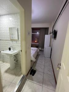 uma casa de banho com um lavatório e uma cama num quarto em Yildiz Hotel em Istambul