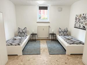 dwa łóżka w pokoju z dwoma stołami w obiekcie BohnApartments Elisa - Wohlfühlapartment mit 2 gratis Parkplätzen und 3 Schlafzimmern - WLAN - Vollausstattung w mieście Erfurt