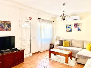 a living room with a couch and a tv at Casa dos Montes in Alvor