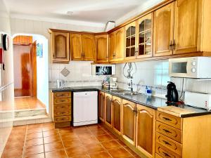 アルヴォルにあるCasa dos Montesのキッチン(木製キャビネット、白い食器洗い機付)