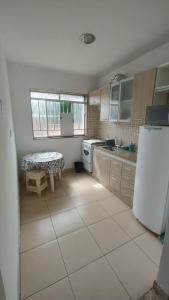 eine Küche mit einem Kühlschrank und einem Tisch darin in der Unterkunft Apt(2) no centro de VR tudo perto até 7 pessoas in Volta Redonda