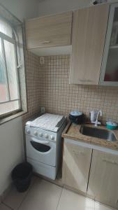 a small kitchen with a stove and a sink at Apt(2) no centro de VR tudo perto até 7 pessoas in Volta Redonda
