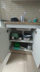 a kitchen with a shelf with pots and pans at Apt(2) no centro de VR tudo perto até 7 pessoas in Volta Redonda