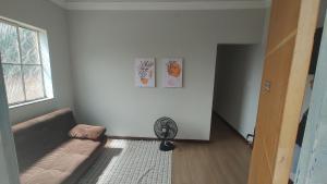 a living room with a couch and a fan at Apt(2) no centro de VR tudo perto até 7 pessoas in Volta Redonda
