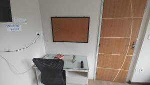 a room with a desk and a chair next to a door at Apt(2) no centro de VR tudo perto até 7 pessoas in Volta Redonda