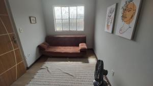 a living room with a brown couch and a rug at Apt(2) no centro de VR tudo perto até 7 pessoas in Volta Redonda