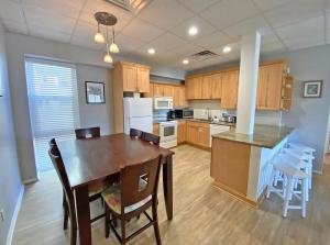 cocina con mesa de madera y comedor en A Wave From It All en Pensacola Beach