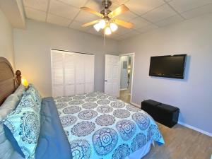 a bedroom with a bed and a flat screen tv at A Wave From It All in Pensacola Beach