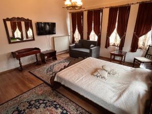 una sala de estar con una cama y un sofá en Хотел Тома, en Sliven
