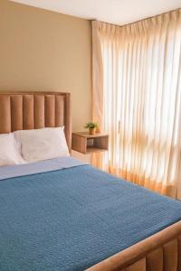 a bedroom with a blue bed with a window at Hermoso Departamento dentro de un Condominio in Chiclayo