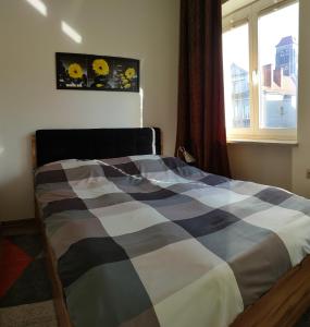 sypialnia z łóżkiem z kocem szachowym w obiekcie Apartament Gdańsk Starówka w Gdańsku