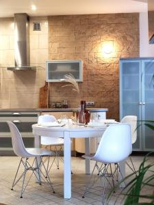 a kitchen with a white table and white chairs at Apartament Nefretete in Łódź