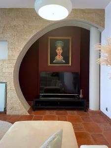 a living room with a painting of a woman on the wall at Apartament Nefretete in Łódź