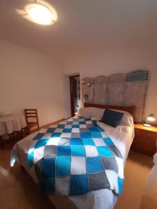 a bedroom with a bed with a blue and white comforter at Casa do Moleiro in Santiago do Cacém