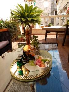 uma bandeja com uma taça de fruta sobre uma mesa em Apartments & Rooms Trogir Stars FREE PARKING em Trogir