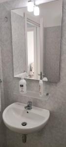 bagno con lavandino e specchio di Le Solite Holiday Rooms a SantʼEufemia Lamezia