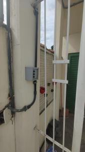 a room with a wall with pipes and a ladder at Apto(3) mt bem localizado, simples mas com tudo in Volta Redonda