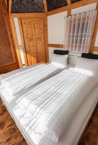 ein großes weißes Bett in einem Zimmer mit Holzdecken in der Unterkunft Ferienwohnung Katja in der Villa Seeblick in Bad Saarow