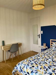 une chambre avec un lit, un bureau et une chaise dans l'établissement Le Citronnier, à Fouesnant