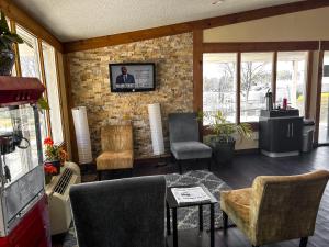 a living room with chairs and a tv on a brick wall at Rodeway Inn in Washington